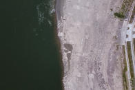 In this aerial photo, the lower than normal bank of the Jialing River is seen in southwestern China's Chongqing Municipality, Friday, Aug. 19, 2022. Ships crept down the middle of the Yangtze on Friday after the driest summer in six decades left one of the mightiest rivers shrunk to barely half its normal width and set off a scramble to contain damage to a weak economy in a politically sensitive year. (AP Photo/Olivia Zhang)