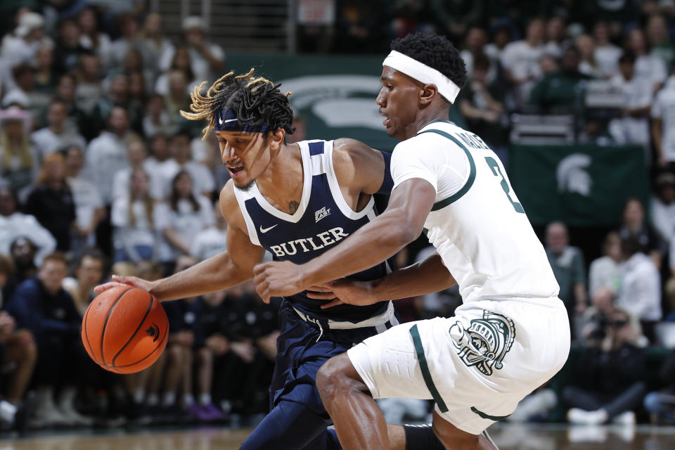 Butler's DJ Davis, left, drives against Michigan State's Tyson Walker during the first half of an NCAA college basketball game Friday, Nov. 17, 2023, in East Lansing, Mich. (AP Photo/Al Goldis)