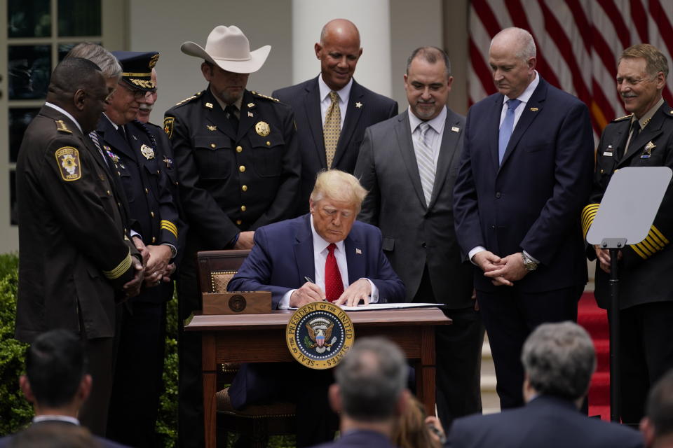President Donald Trump signs an executive order on police reform, in the Rose Garden of the White House, Tuesday, June 16, 2020, in Washington. (AP Photo/Evan Vucci)