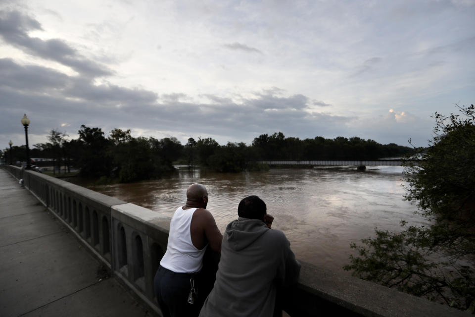 Gerald Generette, derecha, y Maurice Millen observan el río Cape Fear mientras sus niveles continúan aumentando a causa del huracán Florence, en Fayetteville, Carolina del Norte, el lunes 17 de septiembre de 2018. (AP Foto/David Goldman)