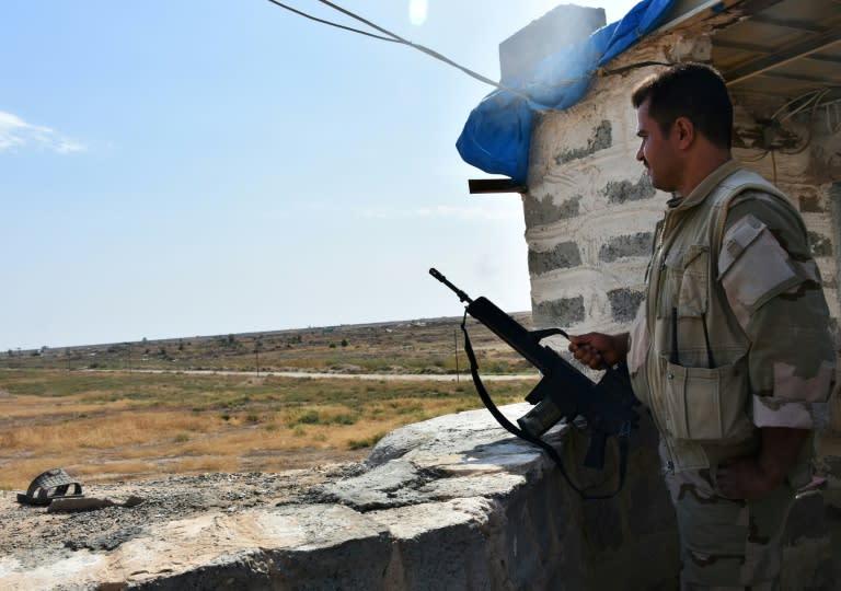 A Kurdish peshmerga fighter holds a position on the southern outskirts of Kirkuk city in an area where Iraqi forces are deployed on October 14