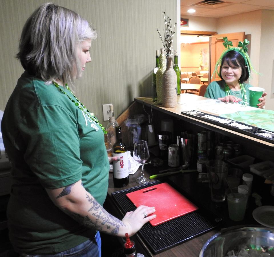 Jessica Davis pours a glass of wine for Delia Meek at the Coshocton Village Inn and Suites for a St. Patrick's Day Pub Crawl. It was the first event for a Designated Outdoor Refreshment Area, which is targeted to bring more people into downtown and Roscoe Village for special events.