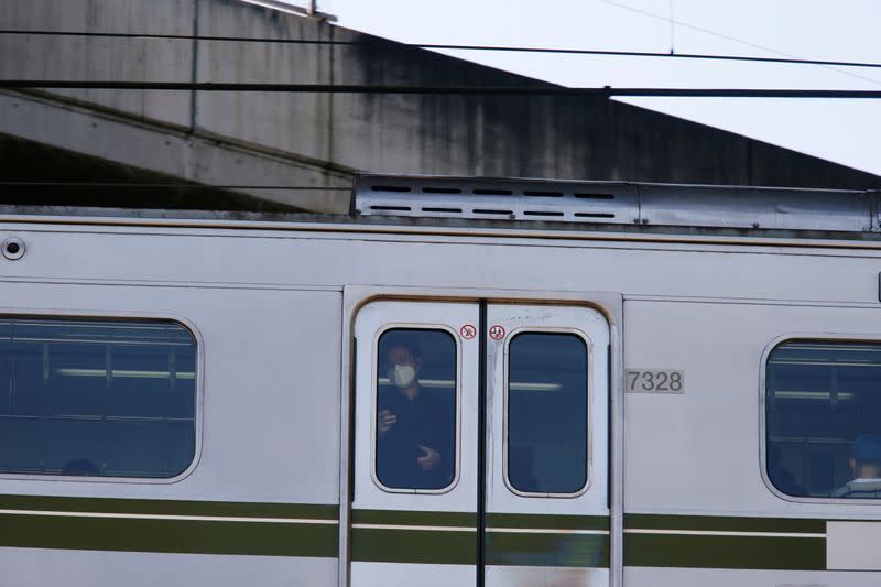 A man wearing a protective face mask to prevent contracting the coronavirus disease (COVID-19) rides on a subway in Seoul