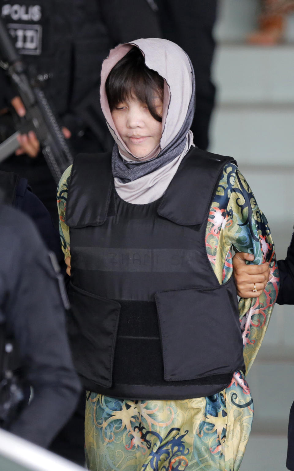 Vietnamese Doan Thi Huong is escorted by police as she leaves after court hearing at Shah Alam High Court in Shah Alam, Malaysia, Thursday, Aug. 16, 2018. Doan and Indonesian Siti Aisyah, who are on trial in the assassination of the North Korean leader's half brother have told the court they will testify in their defense. The women are accused of smearing VX nerve agent on Kim Jong Nam's face last year. They have said they thought it was a prank. A judge ruled Thursday the women should begin entering their defense. (AP Photo/Yam G-Jun)