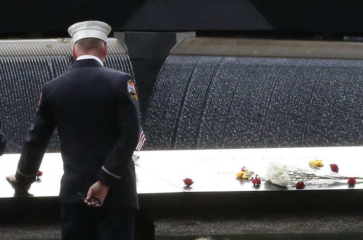 A firefighter touches the names of firefighters carved into the south pool during 15th anniversary ceremony of the attacks on the World Trade Center at the Sept. 11 memorial in New York City. (Photo: Mary Altaffer/AP)