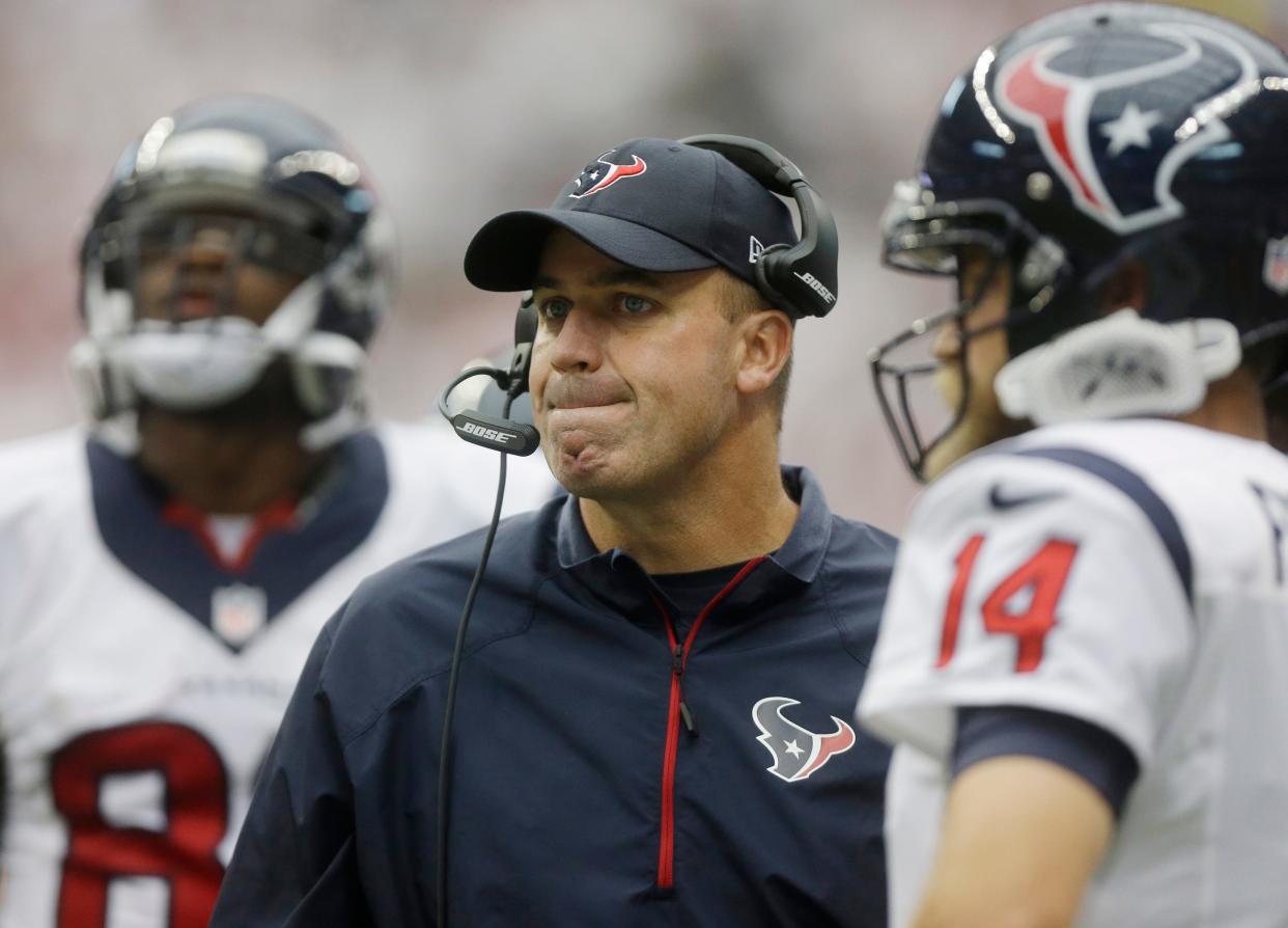 Houston Texans head coach Bill O'Brien, center, with Ryan Fitzpatrick (14) during the second quarter of an NFL football game against the Washington Redskins, Sunday, Sept. 7, 2014, in Houston. (AP Photo/Patric Schneider)