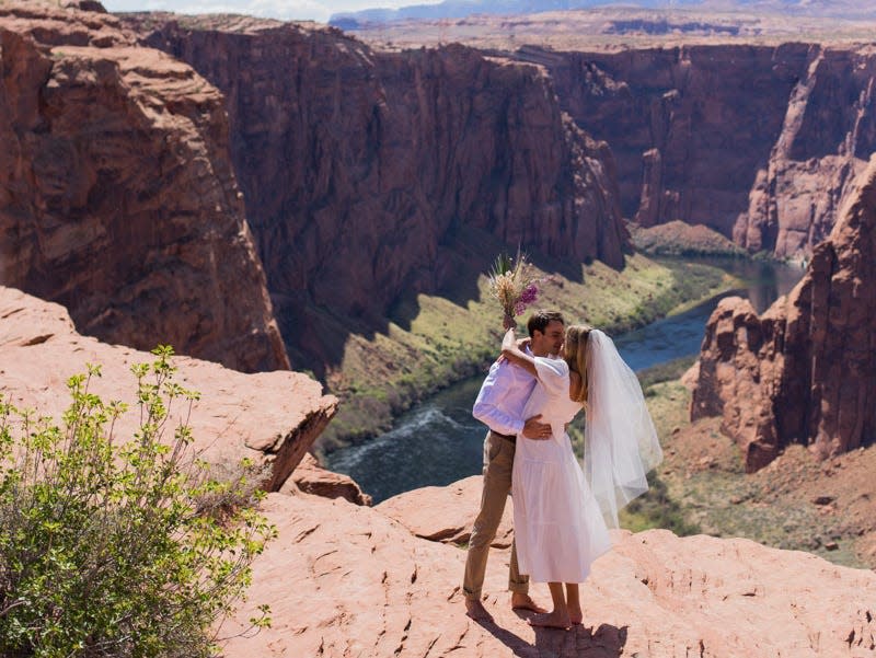 A couple kissing in front of a canyon.