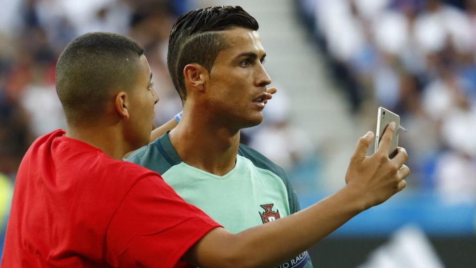 Fan invades the pitch and attempts to take a selfie with Portugal's Cristiano Ronaldo