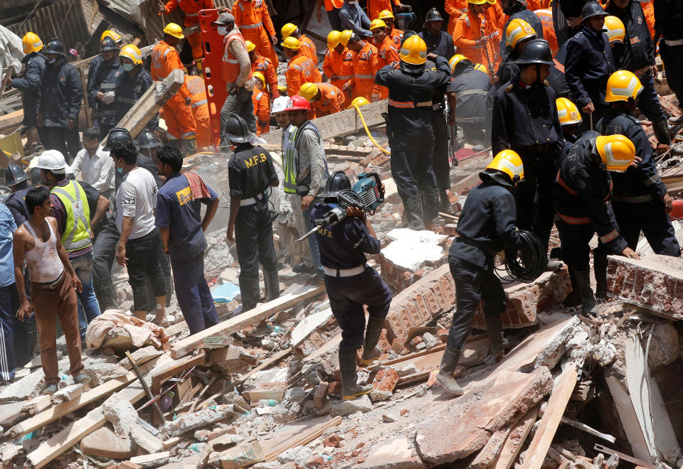 <p>A firefighter arrives with a jackhammer during a search for survivors at the site of a collapsed building in Mumbai, India, Aug. 31, 2017. (Photo: Shailesh Andrade/Reuters) </p>