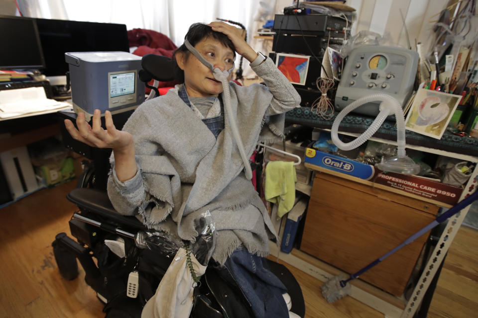 In this photo taken on Monday, Dec. 2, 2019, Grace Lin gestures while speaking at her home in El Cerrito, Calif. An Associated Press review reveals persistent problems during four smaller shutoffs that Pacific Gas & Electric did starting last year so power lines downed by strong winds wouldn’t spark wildfires. “PG&E did nothing to help us who depend on electricity to run our life support,” recounted Lin, a polio survivor who needs a ventilator to breathe and uses an electric wheelchair. “It’s not like we could simply grind our teeth and tough it out by holding our breath.”(AP Photo/Ben Margot)