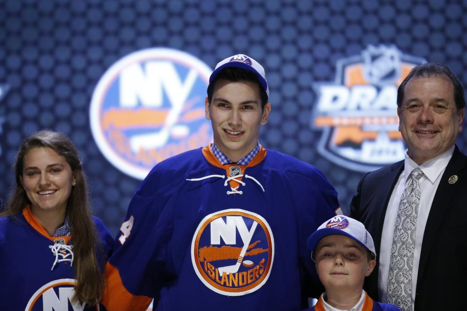Michael Dal Colle stands with New York Islanders officials after being chosen fifth overall during the first round of the NHL hockey draft, Friday, June 27, 2014, in Philadelphia. (AP Photo/Matt Slocum)