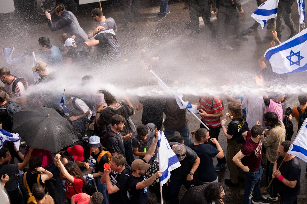 Israeli police use a water cannon to disperse protesters in Tel Aviv (AP)