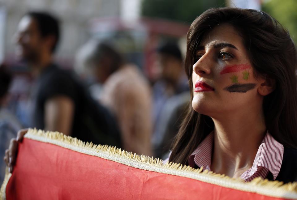 An activist holds a Syrian flag during an event organised by Stop the War Coalition to protest against potential UK involvement in the Syrian conflict in Whitehall, London.