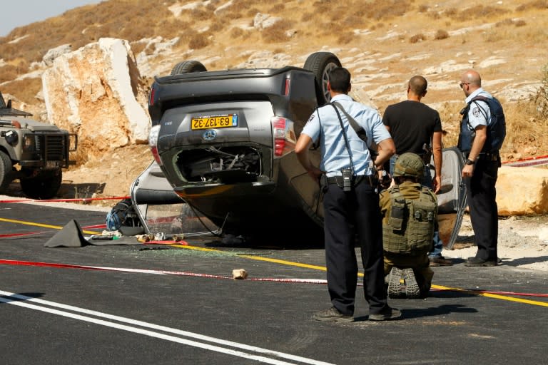 Israeli security forces inspect the scene after a suspected Palestinian gunman opened fire on a settler's car near the West Bank city of Hebron on July 1, 2016