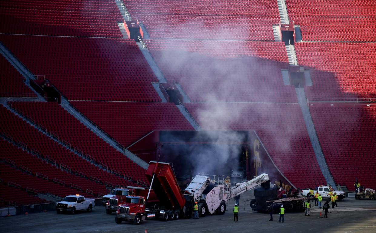 Work crews begin paving the track at the Coliseum in preparation for a NASCAR race.