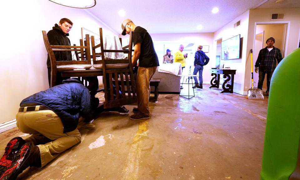 Workers from cleanup company Servpro help rip out flooring at Sandi Ozolins' Port Hueneme home, which suffered water damage Thursday, Dec. 21, 2023. Ozolin lives in the Hueneme Bay senior community.