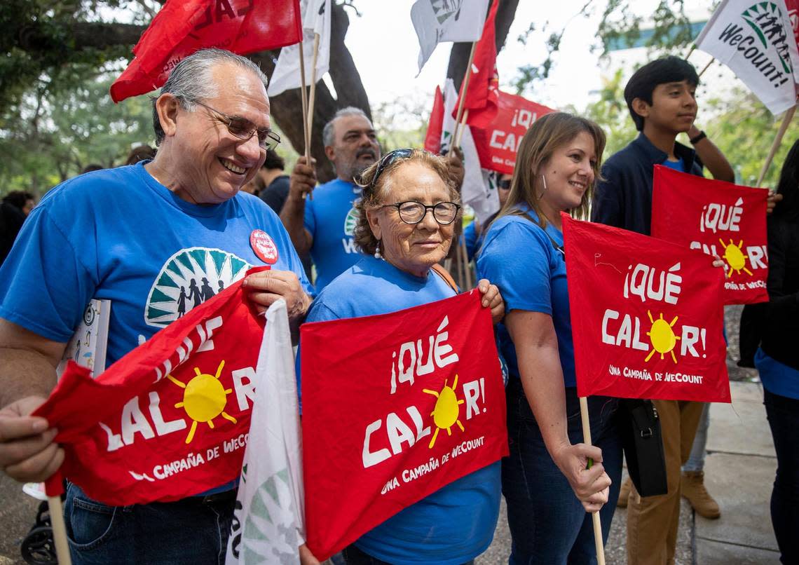 WeCount! Organizing Director Erick S&#xe1;nchez, far-left, and WeCount! member Delia Rodriguez, 72, center, hold flags after attending a press conference outside of Government Center. The group&#x002019;s &#xa1;Que Calor! campaign pushes for Miami-Dade County to require employers to give oudoor workers water, shade and rest to protect them from extreme heat.