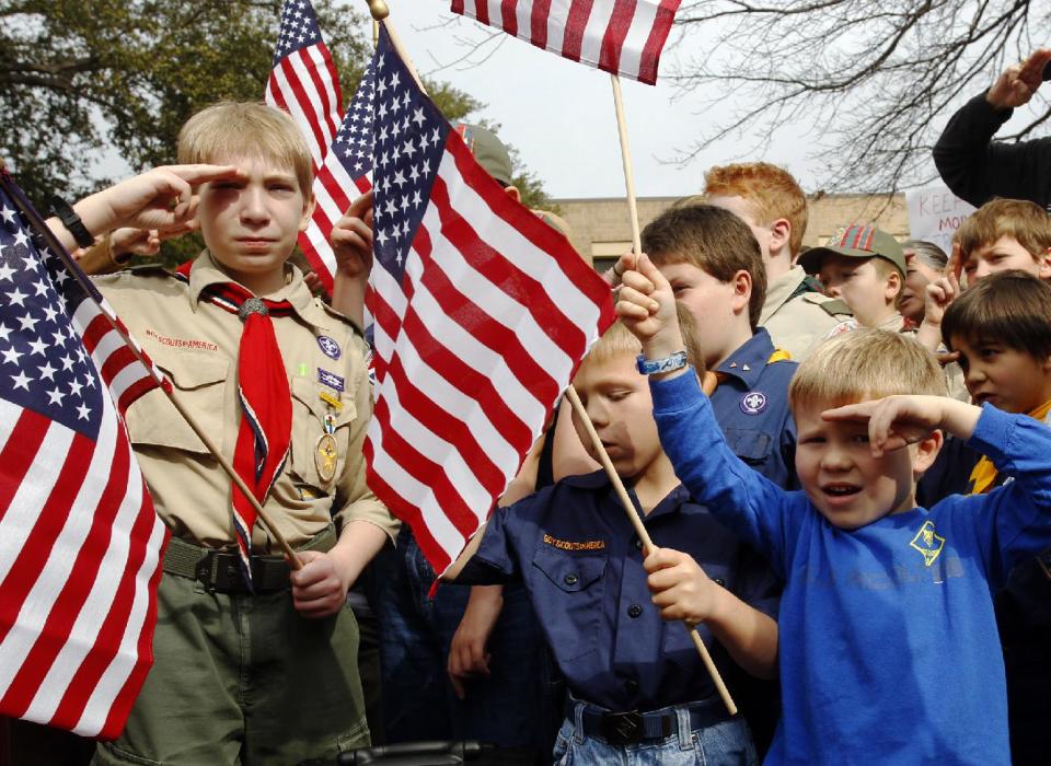 FILE - In this Feb. 6, 2013 file photo, from left, Joshua Kusterer, 12, Nach Mitschke, 6, and Wyatt Mitschke, 4, salute as they recite the pledge of allegiance during the “Save Our Scouts” prayer vigil and rally against allowing gays in the organization in front of the Boy Scouts of America National Headquarters in Dallas, Texas. The BSA said Wednesday, Feb. 12, 2014 that it lost 6 percent of its membership after an often-bruising year in which it announced it would accept openly gay boys for the first time, over the objections of some participants who eventually left the organization. (AP Photo/Richard Rodriguez, File)