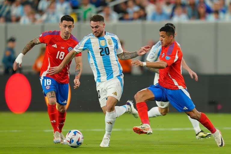 Alexis Mac Allister lucha por la pelota con Alexis Sánchez y Rodrigo Echeverría durante el partido 