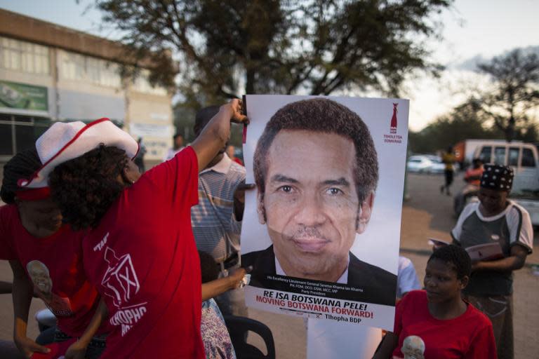 Activists for the ruling Botswana Democratic Party (BDP) distribute posters with the picture of incumbent President Ian Khama, at a pre-election rally in Gaborone, on October 22, 2014