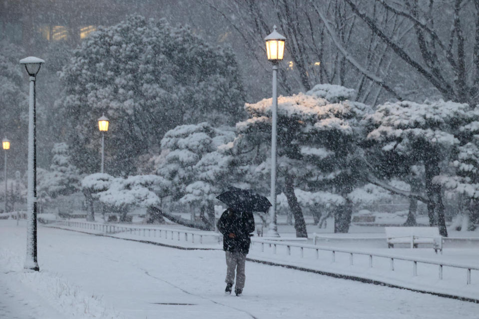 Homme au parapluie marchant sous la neige le 6 janvier 2022 à Tokyo. (Photo by YOSHIKAZU TSUNO/Gamma-Rapho via Getty Images)