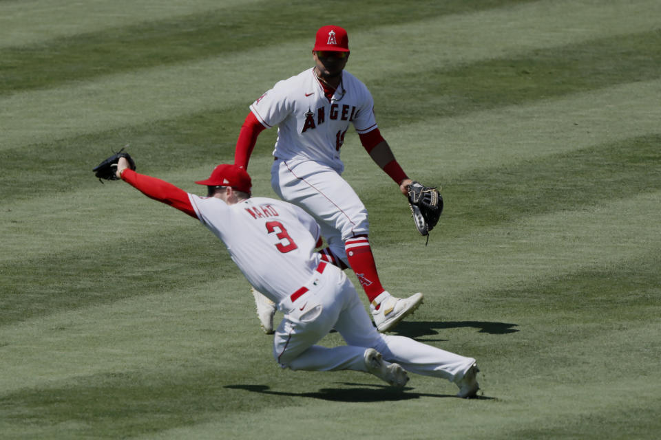 Los Angeles Angels right fielder Taylor Ward, left, leaps in front of center fielder Juan Lagares, right, to catch a fly ball hit by Seattle Mariners designated hitter Jacob Nottingham during the sixth inning of a baseball game in Anaheim, Calif., Sunday, June 6, 2021. (AP Photo/Alex Gallardo)