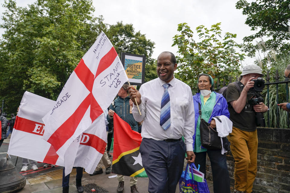 Anthony Brown, director of the Windrush Defenders C.I.C. marches holding an England's flag, as he takes part in the annual Afrikan Emancipation Day Reparations march, in Brixton, London, Sunday, Aug. 1, 2021. Black people whose right to live in the U.K. was illegally challenged by the government marked the anniversary Sunday of the act that freed slaves throughout the British Empire, drawing a direct link between slavery and the discrimination they suffered. Dozens of campaigners gathered in Brixton, a center of the Black community in south London, to back the international drive for reparations for the descendants of enslaved Africans and demand legislation to compensate legal residents who were threatened with deportation in what is known as the Windrush Scandal. (AP Photo/Alberto Pezzali)