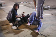 <p>A man gets help after being overcome by tear gas that police launched at demonstrators protesting the killing of teenager Michael Brown on August 17, 2014 in Ferguson, Missouri. Police shot smoke and tear gas into the crowd of several hundred as they advanced near the police command center which has been set up in a shopping mall parking lot. Brown was shot and killed by a Ferguson police officer on August 9. Despite the Brown family’s continued call for peaceful demonstrations, violent protests have erupted nearly every night in Ferguson since his death. (Scott Olson/Getty Images) </p>