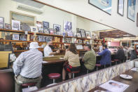 Customers are seen reflected in a mirror dining inside at Pellegrini's Espresso Bar in Melbourne, Australia, Wednesday, Oct. 28, 2020. In Melbourne, Australia's former coronavirus hot spot, restaurants, cafes and bars were allowed to open and outdoor contact sports can resume Wednesday, emerging from a lockdown due to the coronavirus outbreak. (AP Photo/Asanka Brendon Ratnayake)