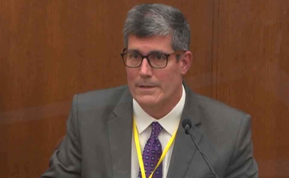 In this image from video, Dr. Andrew Baker, Hennepin County Medical Examiner, testifies as Hennepin County Judge Peter Cahill presides Friday, April 9, 2021.