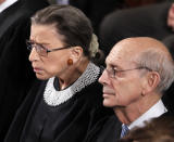FILE - In this Jan. 24, 2012, file photo Supreme Court Justices Ruth Bader Ginsburg and Stephen Breyer listen to President Barack Obama deliver his State of the Union address to a joint session of Congress at the Capitol in Washington. Ginsburg didn’t put on her judge’s robe without also fastening something around her neck. Ginsburg called her neckwear collars, or jabots, and they became part of her signature style, along with her glasses, lace gloves and fabric hair ties known as scrunchies. (AP Photo/Evan Vucci, File)