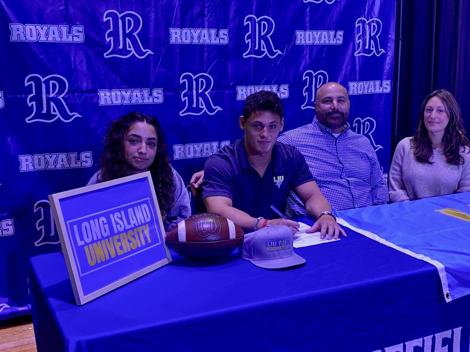 Ridgefield senior Max Ycaza signs his letter of intent to play football at Long Island University. Joining him, from left, Havana Ycaza, Christopher Costello and Yvette Ycaza.