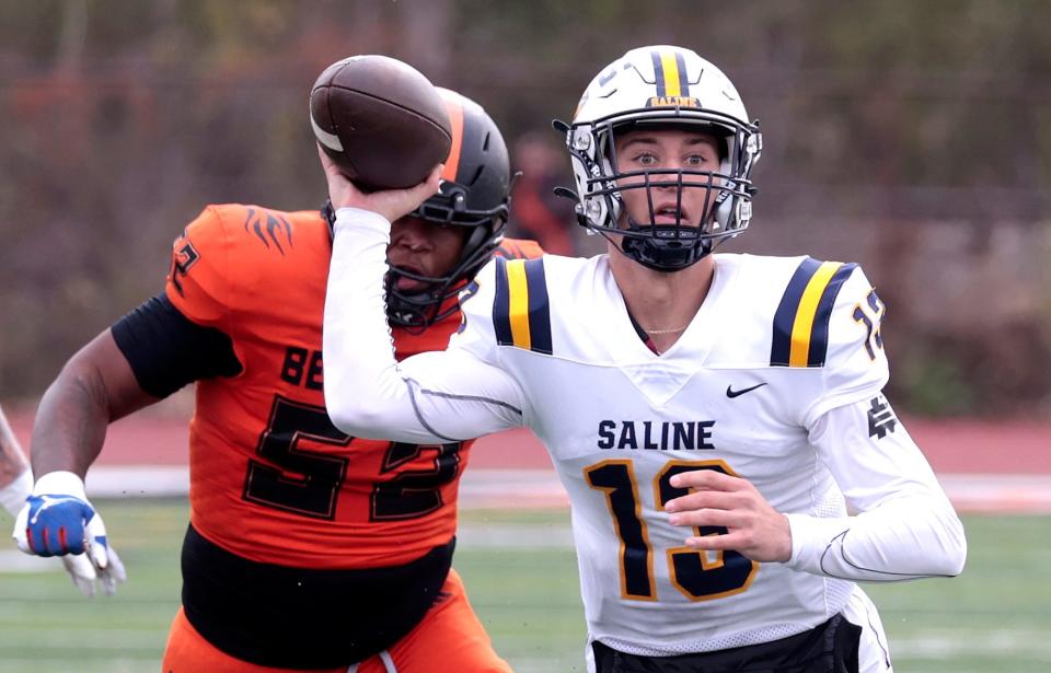 Belleville's Ronald Jackson chases down Saline quarterback CJ Carr as he looks to throw during first-half action in the MHSAA Division 1 playoff game between Saline and Belleville at Belleville High School on Saturday, Nov. 4, 2023.