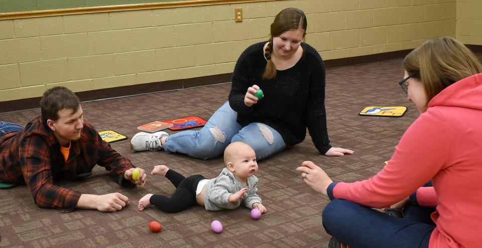 Seven-month-old Myra Zimmerman enjoys the shakers with Sarah Seegert, the youth services technician at Summerfield-Petersburg Branch Library, and her parents,
Riley and Layne Zimmerman. The library's baby sign language program also includes books, music and toys for learning and playing.