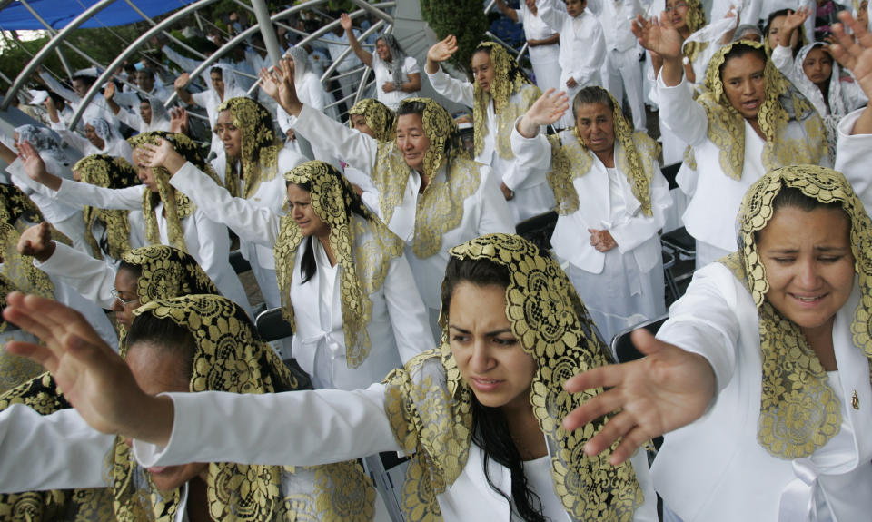 ADDS FIRST NAME - FILE - In this Aug. 14, 2009 file photo, worshippers raise their hands at "La Luz Del Mundo," or Light of the World church during a Holy Dinner celebration, one of the church's principal religious events, at the Hermosa Provincia Temple in Guadalajara, Mexico. On Tuesday, June 4, 2019, California authorities charged Naasón Joaquín García, the leader and self-proclaimed apostle of the church based in Mexico that claims over 1 million followers, with child rape, human trafficking and producing child pornography. (AP Photo/Carlos Jasso, File)