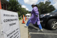 Liza Collins, a travel nurse from Ville Platte, La., takes a COVID-19 test sample into the Rutherford County Health Department, Thursday, July 2, 2020, in Murfreesboro, Tenn. Tennessee Gov. Bill Lee issued a stern warning to the public Wednesday as Tennessee registered its highest daily increase in positive COVID-19 tests for the third time in a week and a half. (AP Photo/Mark Humphrey)