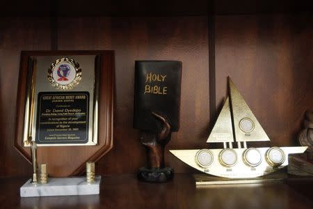 A mini sculpture in the shape of the Bible is displayed next to an award (L) for Bishop David Oyedepo, founder of the Living Faith Church, also known as the Winners' Chapel, recognising him his contribution to the development of Nigeria, in his office in Ota district, Ogun state, some 60 km (37 miles) outside Nigeria's commercial capital Lagos September 28, 2014. REUTERS/Akintunde Akinleye