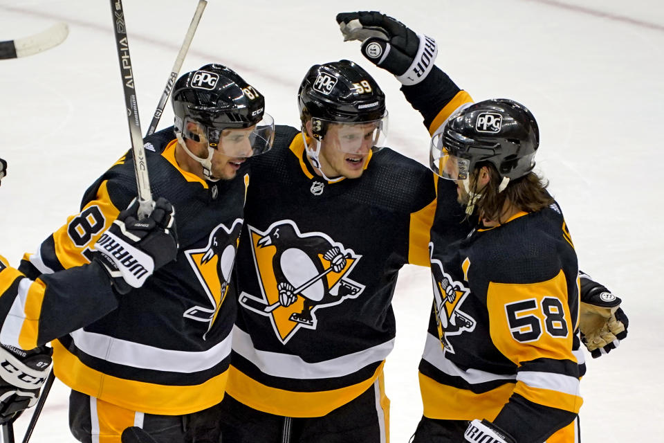 Pittsburgh Penguins' Jake Guentzel (59) celebrates after scoring with Sidney Crosby (87) and Kris Letang during the third period of an NHL hockey game against the New York Rangers in Pittsburgh, Sunday, Jan. 24, 2021. The Penguins won 3-2. (AP Photo/Gene J. Puskar)