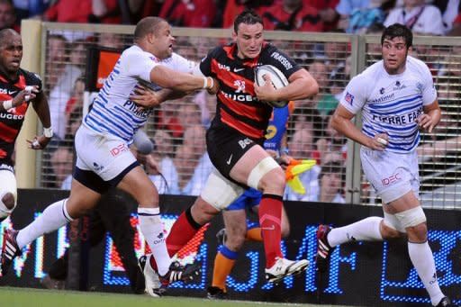 Toulouse's number eight Louis Picamoles (C) is tackled by Castres's prop Luc Ducalcon during their Top 14 rugby match in Toulouse's stadium. Former champions Toulouse secured their place in the final of the French Top 14 championship with a 24-15 semi-final win over Castres