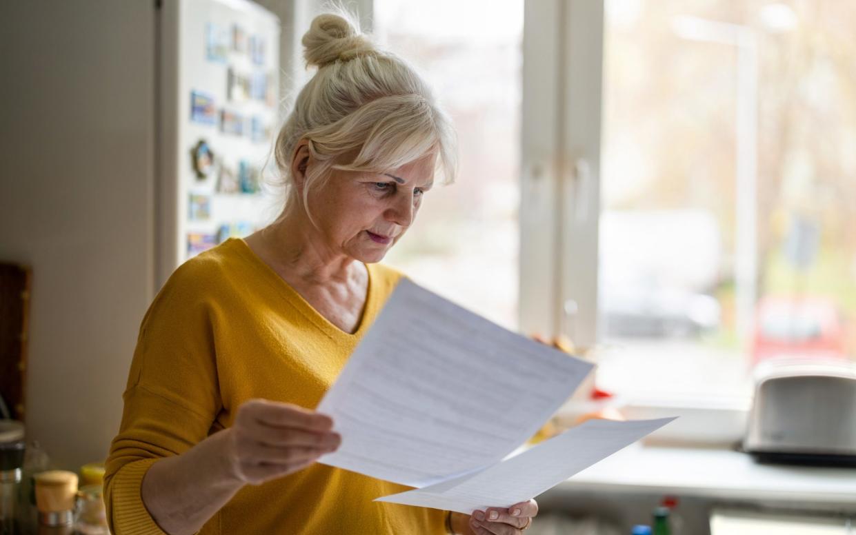 Woman in her late 60s looking at bills