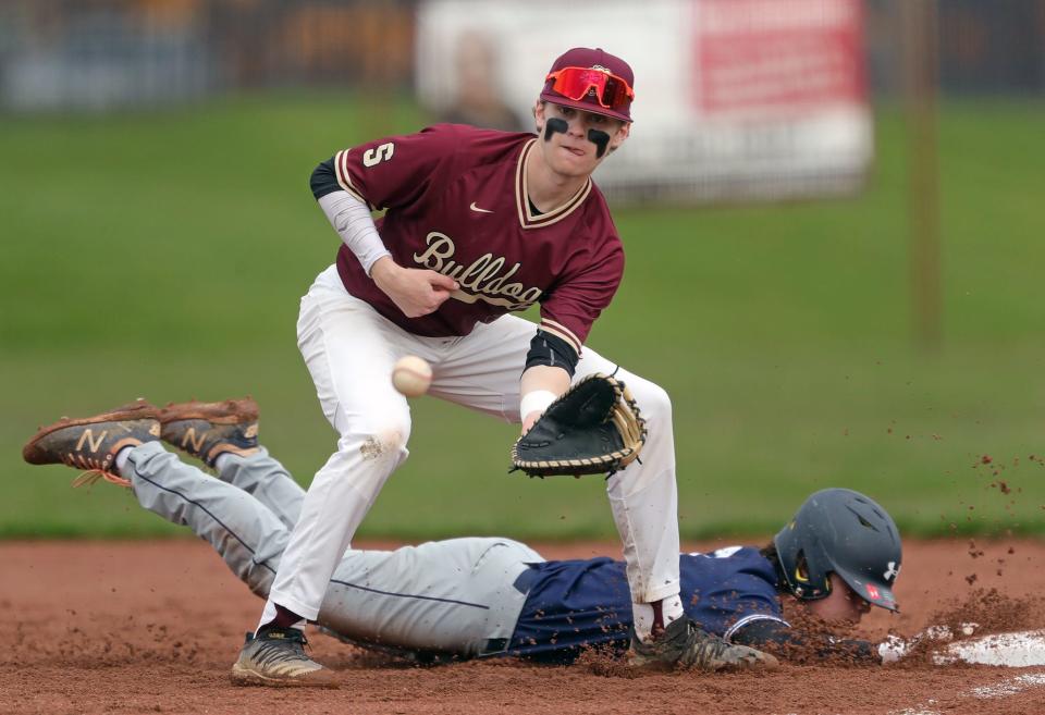 Stow first baseman Zac Fuller eyes down the throw from home as Twinsburg baserunner Ernie Phillips dives back to first during the second inning of a baseball game on Friday in Stow.