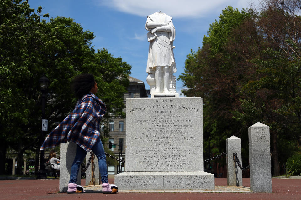 A woman looks at a statue depicting Christopher Columbus which had its head removed at Christopher Columbus Waterfront Park on June 10, 2020 in Boston, Massachusetts. The statue was beheaded overnight and is scheduled to be removed by the City of Boston. (Tim Bradbury/Getty Images)