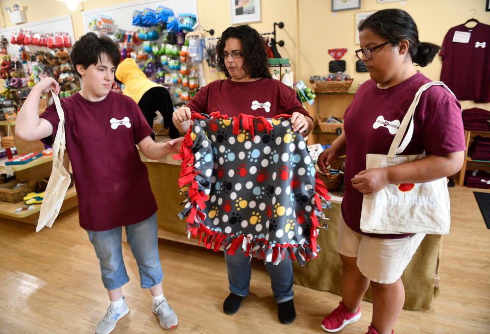 Manager Erica Richman, center, and Pride Paws participants Mary Zimak, left, and Elizabeth Mannino, show off some of the items that are made and sold at the Medford store. July 7, 2022.