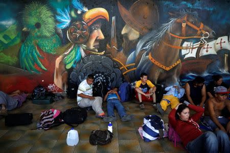 Migrants, part of a caravan travelling to the U.S., rest next to a mural as they wait to cross the border between Guatemala and Mexico, in Tecun Uman, Guatemala, November 19, 2018. REUTERS/Alkis Konstantinidis