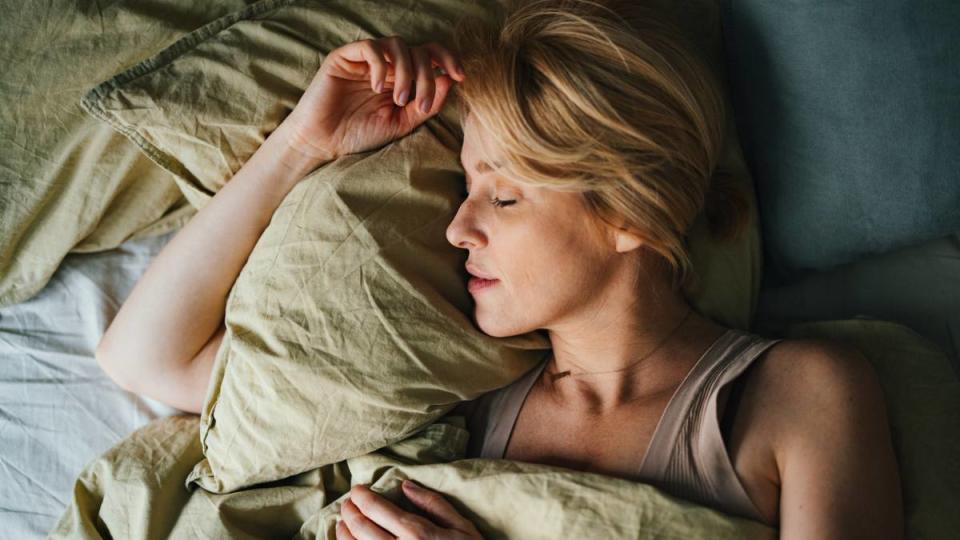 sleepy girl mocktail: Top view of a beautiful blonde woman sleeping in bed. She looks peaceful and fast asleep.