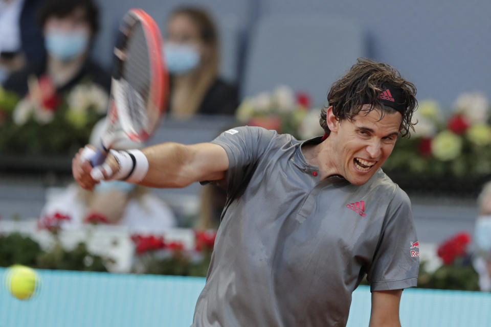 FILE - Dominic Thiem of Austria returns the ball to Marcos Giron of the U.S. during their match at the Madrid Open tennis tournament in Madrid, Spain, on May 4, 2021. Former finalist Dominic Thiem has announced that he is withdrawing from the Australian Open and will instead begin his 2022 season in South America. Thiem said he had a “slight set back” in his return from a wrist injury but is “now feeling well again.” Thiem was hurt in June while playing in the Mallorca Open and also missed Wimbledon and the U.S. Open this year. The Australian Open begins Jan. 17. Thiem reached the final in Melbourne in 2020, losing to Novak Djokovic. (AP Photo/Paul White, File)