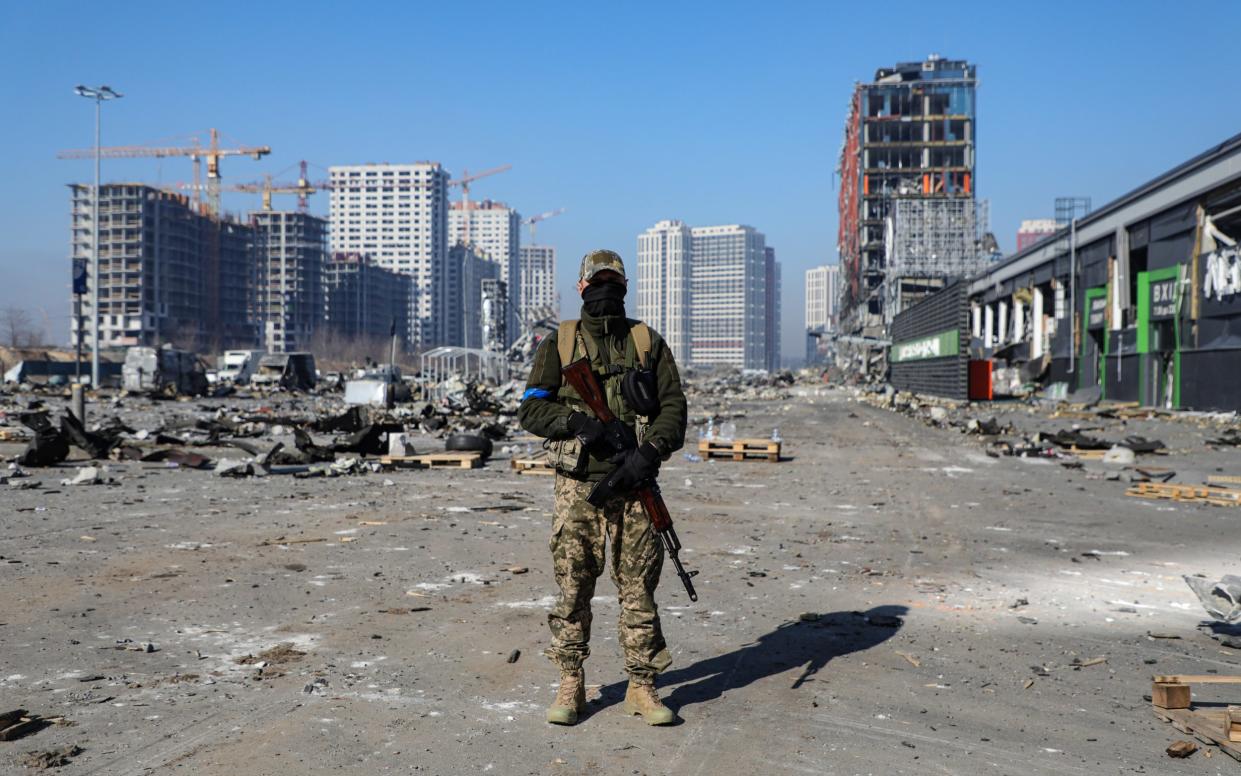 A soldier is pictured outside a shopping mall ruined as a result of a missile strike carried out by the Russian troops in the Podilskyi district of Kyiv - Yuliia Ovsiannikova / Avalon