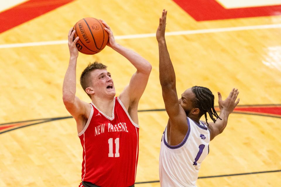 New Palestine High School junior Julius Gizzi (11) shoots while being defended by Ben Davis High School senior Mark White (1) during the second half of an IHSAA Class 4A Boys Regional basketball game, Saturday, March 9, 2024, at Southport High School. Ben Davis won, 70-59.