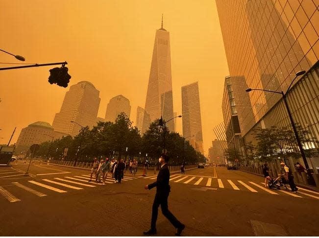 Pedestrians are seen walking this week in New York City where smoke from wildfires in Canada have created an unhealthy haze.