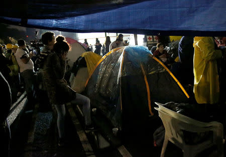 Relatives wait for news of their loved ones next to a collapsed building after an earthquake in Mexico City, Mexico September 22, 2017. REUTERS/Henry Romero